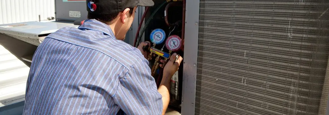 HVAC technician servicing a condenser unit in White Marsh